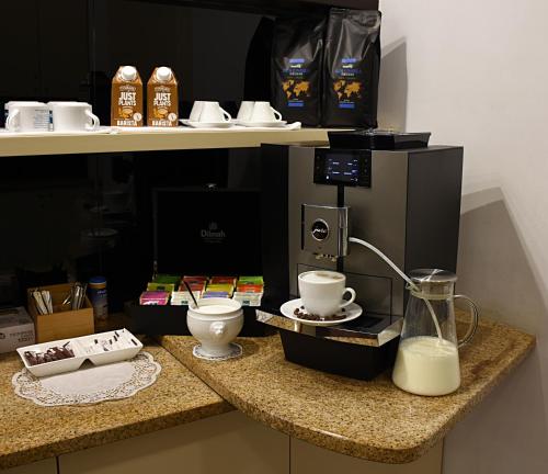Eine Theke mit Kaffeemaschine und Milchkännchen. in der Unterkunft Hotel Pod Lwem in Elblag