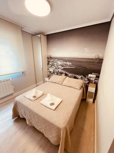 a bedroom with a bed with two towels on it at Alojamientos CATAMARAN in Castro-Urdiales