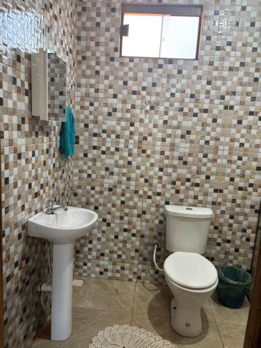 ein Badezimmer mit Toilette und Waschbecken in der Unterkunft Hospedagem Nova Terra in Alto Paraíso de Goiás