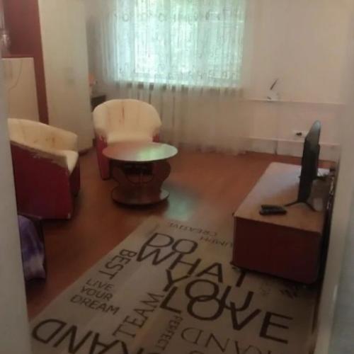 een woonkamer met een bank, een tafel en een tv bij Мономаха 27 Центр in Dnipro