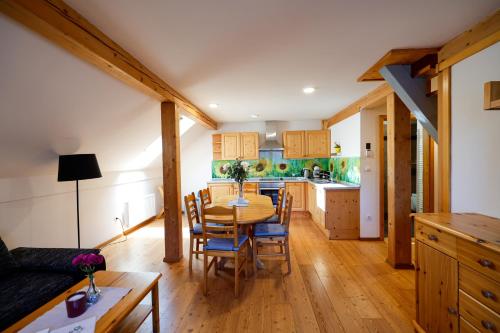 Una cocina y un comedor con mesa y sillas. en Apartments Budinek, en Kranjska Gora