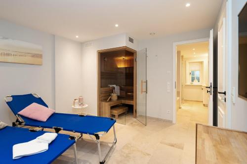 einen blauen Stuhl in einem Zimmer mit Bad in der Unterkunft Haus Carstensen Nord in Keitum