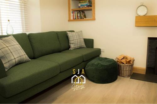 库勒Beachside Cottage - SJA Stays - Modern 3 Bed House的带壁炉的客厅内的绿色沙发