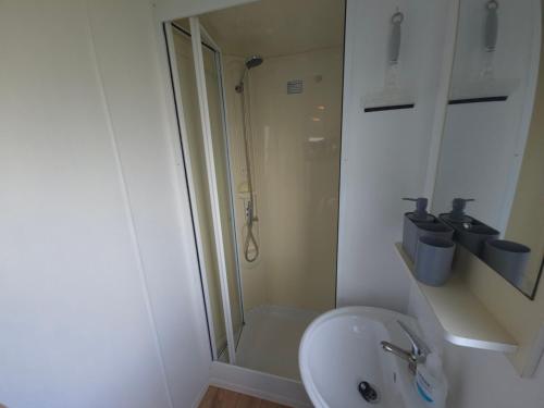 ein weißes Badezimmer mit Dusche und Waschbecken in der Unterkunft The Retreat at Marine Holiday Park in Rhyl
