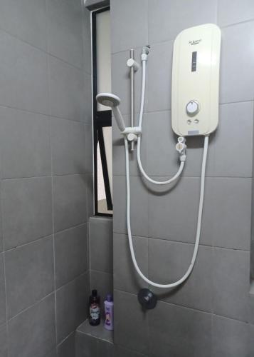 a shower in a bathroom with a white shower head at Homestay MKH Boulevard 1 in Kajang