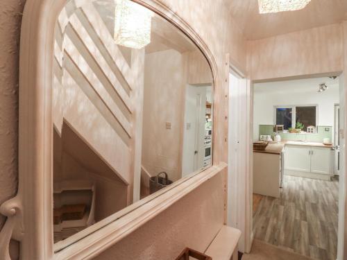 een gang met een grote spiegel aan de muur bij Berkley Cottage in Coggeshall