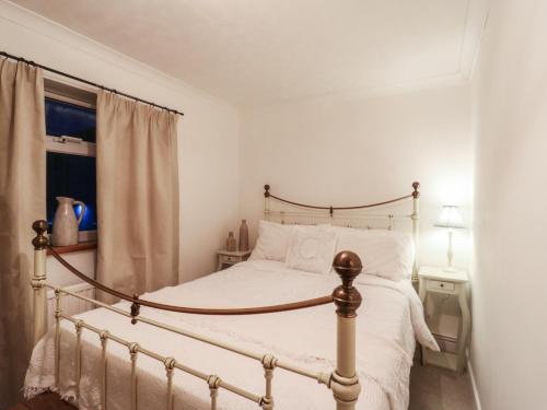a bedroom with a bed and a window at Berkley Cottage in Colchester