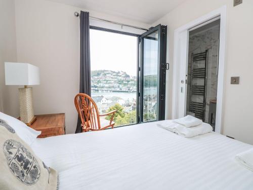 a bedroom with a large white bed and a window at Ty'r Ddraig in Dartmouth