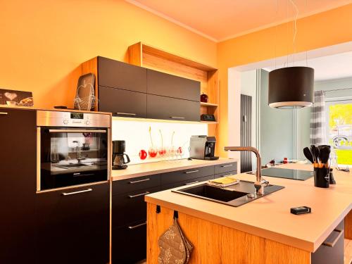 バート・ザクサにあるDer Fuchsbau - Ferienwohnung "Auszeit Harz" - 3 Hunde willkommen - eingezäunter Gartenの黒い冷蔵庫とシンクのあるキッチン