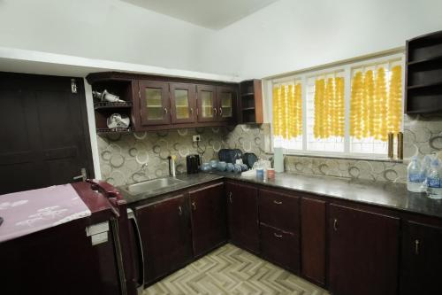 阿勒皮Sukhalaya Lake Villa的厨房配有木制橱柜、水槽和窗户。