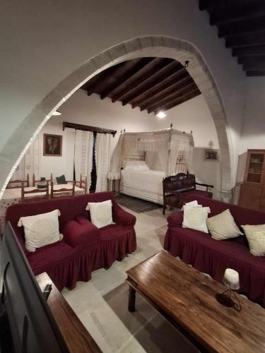 a living room with two red couches and an archway at Lοfou-Queen in Lofou