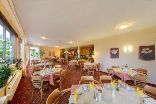 a restaurant with tables and chairs in a room at Montana Hotel Senden in Senden