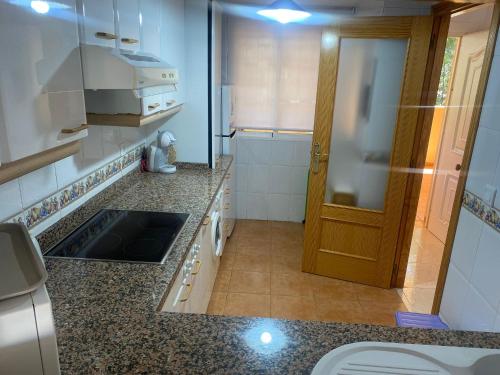 a kitchen with a sink and a wooden door at Vistamar - Inalko in Alcossebre
