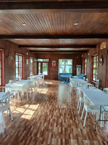 a banquet hall with white tables and white chairs at El Complejo Turístico KUMA MANDJI de Corsico 