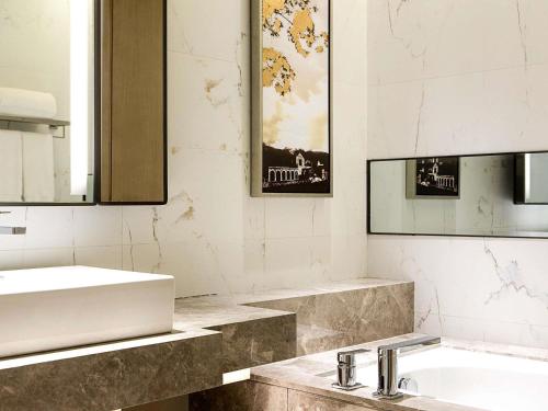 um banheiro com uma pia e um espelho em Pullman Taiyuan em Taiyuan