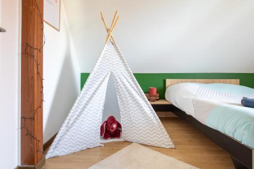 a bedroom with a teepee tent next to a bed at Maison confortable & familiale, proche Colmar et plus beaux coins d'Alsace in Muntzenheim