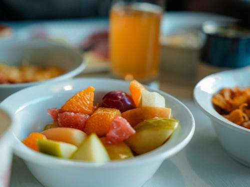 un bol de fruta en una mesa con otros tazones de comida en ibis budget Sète centre, en Sète