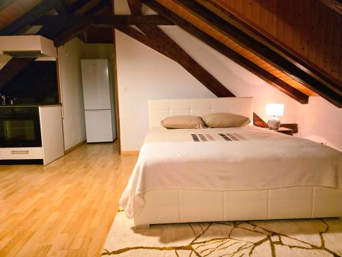 a bedroom with a large white bed in a attic at Petit studio centre ville in Montreux