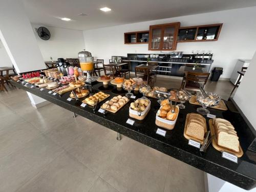 a buffet of bread and pastries on a table at Pousada do Batata in Capitólio