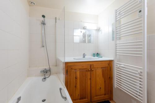 a bathroom with a tub and a sink and a bath tub at Gîte Centre Luz-Saint-Sauveur in Luz-Saint-Sauveur