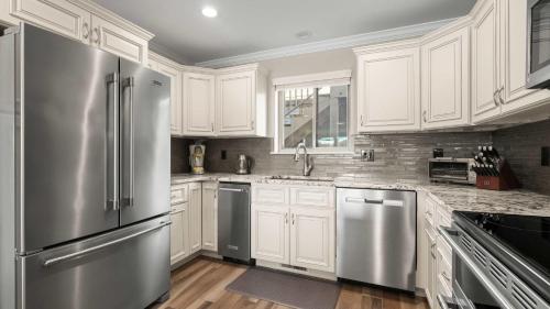 a kitchen with white cabinets and stainless steel appliances at Lakeside Haven - Condo for 8 in Sunrise Beach