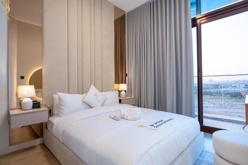 a bedroom with a white bed with a large window at Bright 1BR with Balcony the Gate, Masdar City in Abu Dhabi