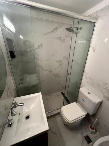 a bathroom with a shower and a toilet and a sink at Stuart's Apartment in Mar del Plata