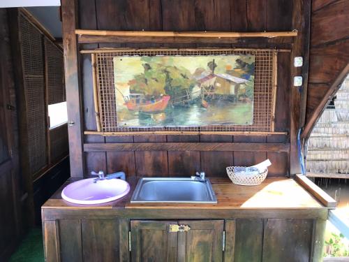 a bathroom with a sink and a painting on the wall at Homestay Phong de Pêche in Ấp Tân Bình (1)