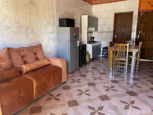 Una sala de estar con un sofá y una mesa y una cocina. en Las Palmeras, en Chuí