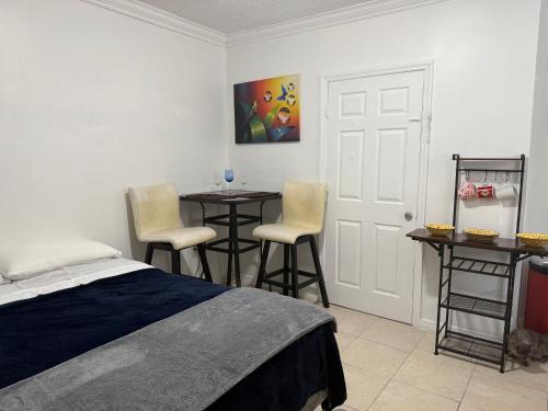 een slaapkamer met een bed en 2 tafels en stoelen bij My Garden in Miami Florida in Palmetto Bay