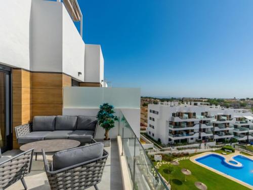 a balcony with a couch and chairs and a pool at Apartment Aire Residencial by Interhome in Villacosta