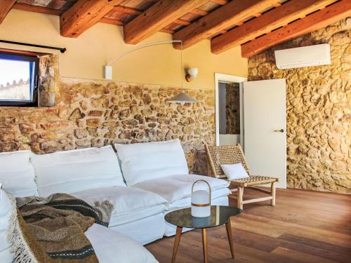 - un salon avec un canapé blanc et un mur en pierre dans l'établissement Holiday Home Can Caritat by Interhome, à Pals