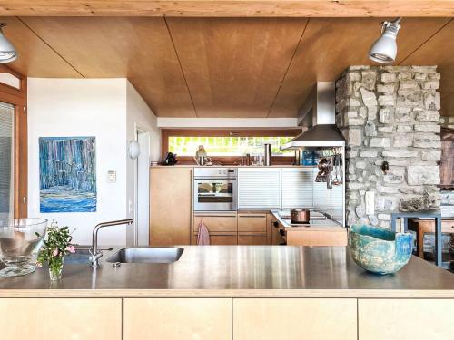 uma cozinha com um balcão e uma parede de pedra em Holiday Home Heuberg by Interhome em Langwied