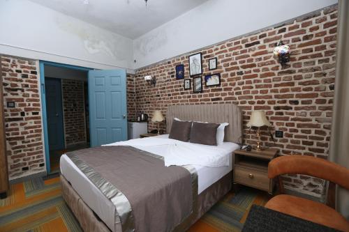 een slaapkamer met een bed en een bakstenen muur bij Sur Central OTEL in Diyarbakır
