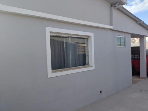 a window on the side of a white building at Kitnet Boa Vista in Sete Lagoas