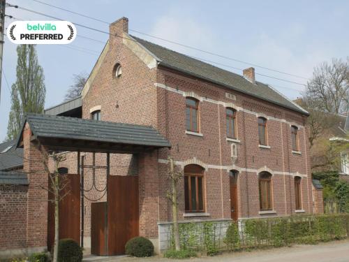 an old red brick building with a black roof at Monastery Retreat in Blossoming Limburg in Sint-Truiden