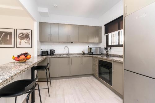 a kitchen with white cabinets and a counter top at Cristian Sur Luxury 2 Bedroom Apartment in Los Cristianos