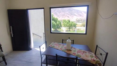 a table with a candle on it in a room with a window at Airecillos de la Banda in Tilcara