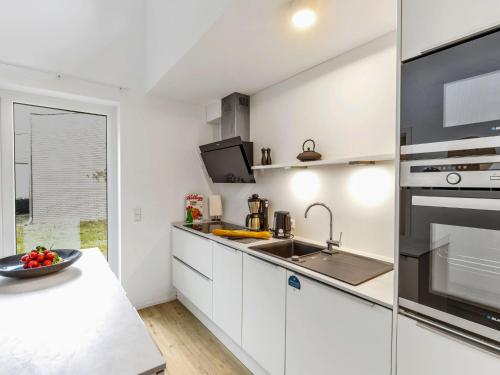 a kitchen with white cabinets and a sink at Holiday Home Sonnenpfad by Interhome in Lembruch