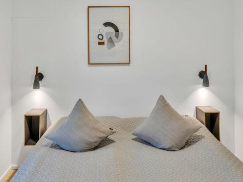 a white bedroom with a bed with blue pillows at Apartment Imort by Interhome in Lembruch