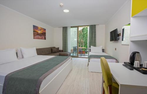 a hotel room with two beds and a couch at Citrus Park Hotel in Antalya