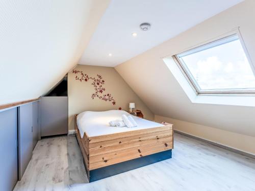 een slaapkamer op zolder met een bed en een raam bij Holiday Home Polderzicht with parking by Interhome in Mispelburg