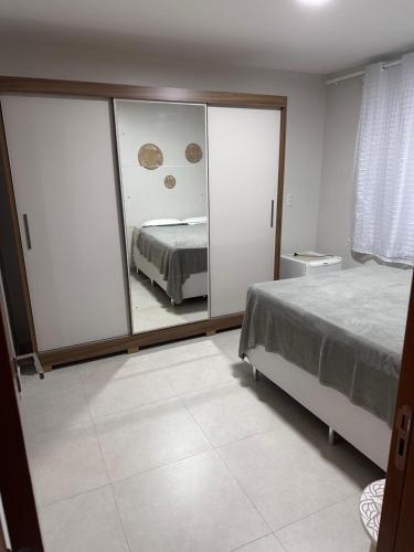 a bedroom with a bed and a mirror at Apê do Tigas - Baía do Pontal in Ilhéus