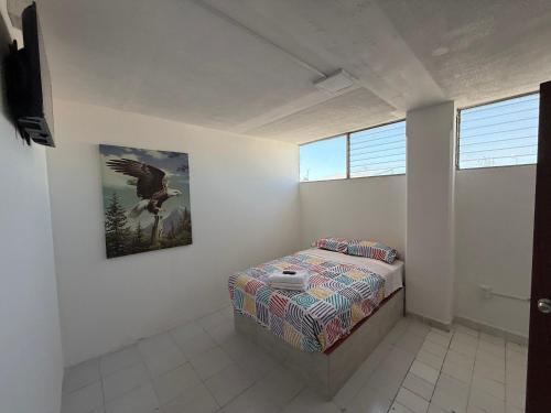 a bedroom with a bed and a painting on the wall at Hotel la Cruz in Querétaro