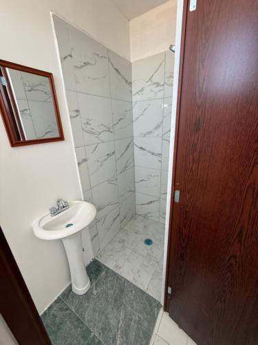 a bathroom with a sink and a shower at Hotel la Cruz in Querétaro