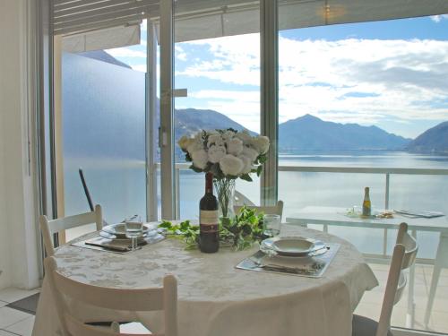 a table with a vase of flowers on a table with a view at Studio Vista Lago by Interhome in Castagnola