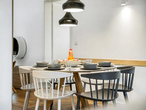 a dining room table with chairs and aendant light at Holiday Home Komfortzone by Interhome in Lembruch