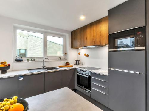 a kitchen with stainless steel appliances and wood cabinets at Holiday Home Komfortzone by Interhome in Lembruch