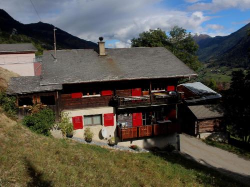 a house on a hill with red doors and a balcony at Apartment Sandgrube 2- OG Süd by Interhome in Mörel