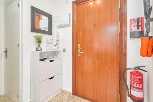 a hallway with a wooden door and a shelf at Albaida 3G Nerja in Nerja